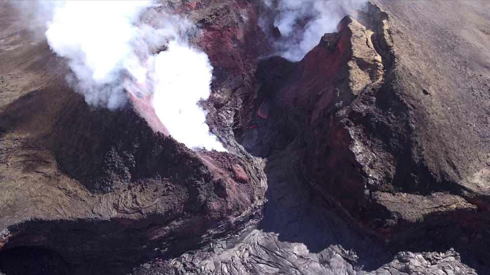 In this Aug. 11, 2018 aerial photo provided by the United States Geological Survey shows diminished volcanic activity on Kilauea's lower East Rift Zone. Slowing activity at Hawaii's Kilauea volcano is prompting scientists to downgrade their alert level for the mountain. The U.S. Geological Survey said Friday, Aug. 17, it issued a "watch" for Kilauea's ground hazards; that's down from a "warning." Geologists say lava mostly stopped flowing on Aug. 6. (USGS via AP)