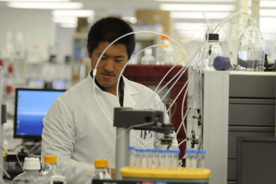 Protein Sciences scientist Guang Liu runs liquid through a purifying machine in Meriden, Conn.