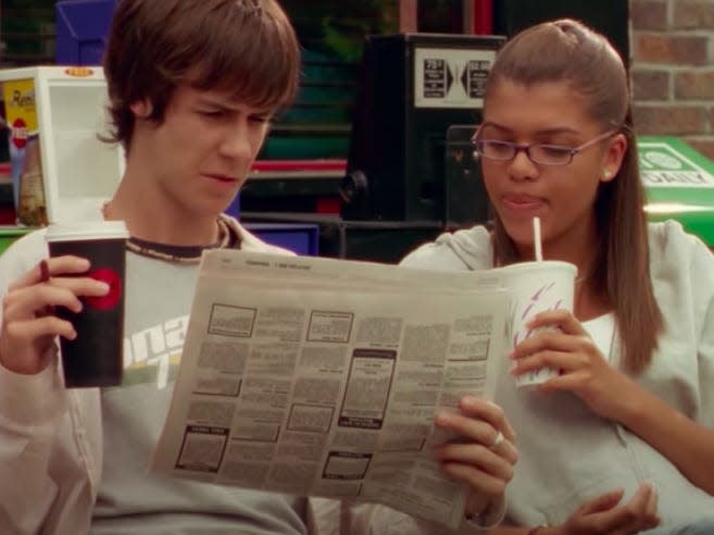 jt and liberty looking through a newspaper on degrassi next generation