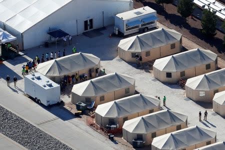 FILE PHOTO: Immigrant children now housed in a tent encampment under the new "zero tolerance" policy by the Trump administration are shown walking in single file at the facility near the Mexican border in Tornillo, Texas, U.S. June 19, 2018. REUTERS/Mike Blake