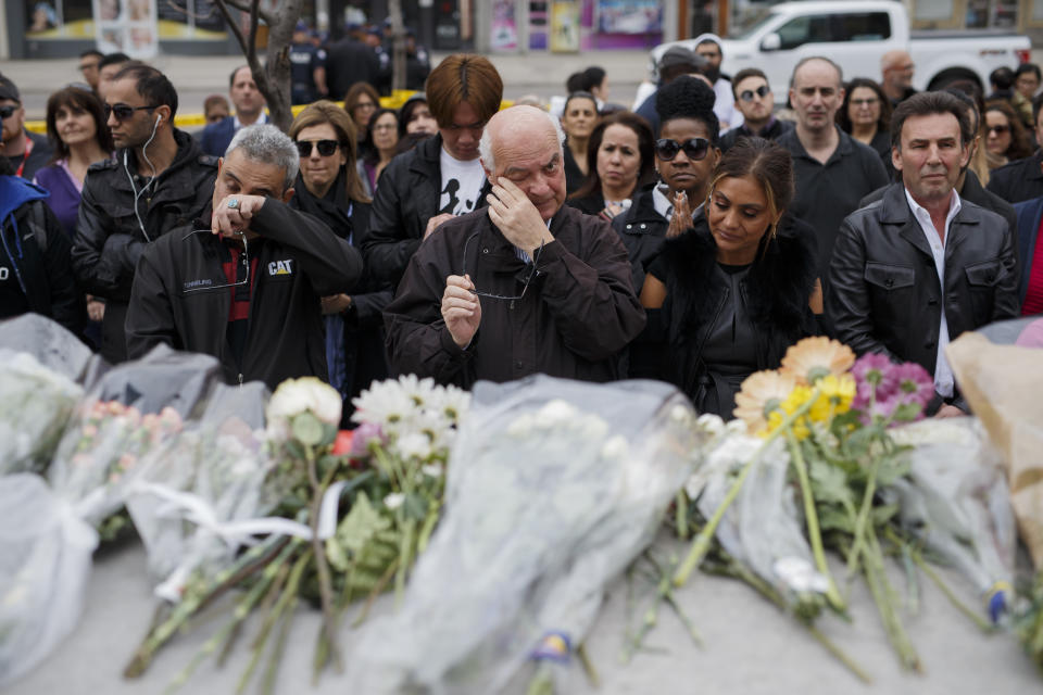 <p>People gather for a moment of silence at a memorial for victims of the mass killing on Yonge St. at Finch Ave. on April 24, 2018 in Toronto, Canada. (Photo: Cole Burston/Getty Images) </p>