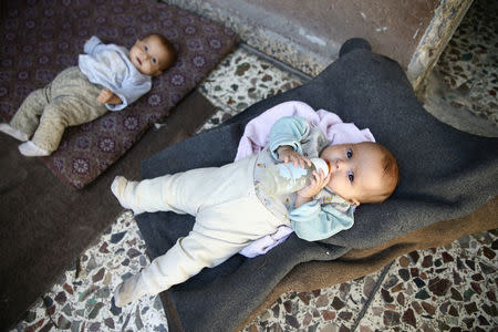 Six-month-old twins Safa and Marwa, who suffer from malnutrition, are seen at their home in the Hazzeh area, in the eastern Damascus suburb of Ghouta, Syria, October 25, 2017. REUTERS/Bassam Khabieh