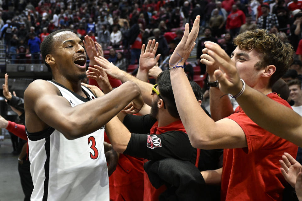 San Diego State guard Micah Parrish (3) celebrates with fans after San Diego State defeated UC Irvine 63-62 in an NCAA college basketball game Saturday, Dec. 9, 2023, in San Diego. (AP Photo/Denis Poroy)