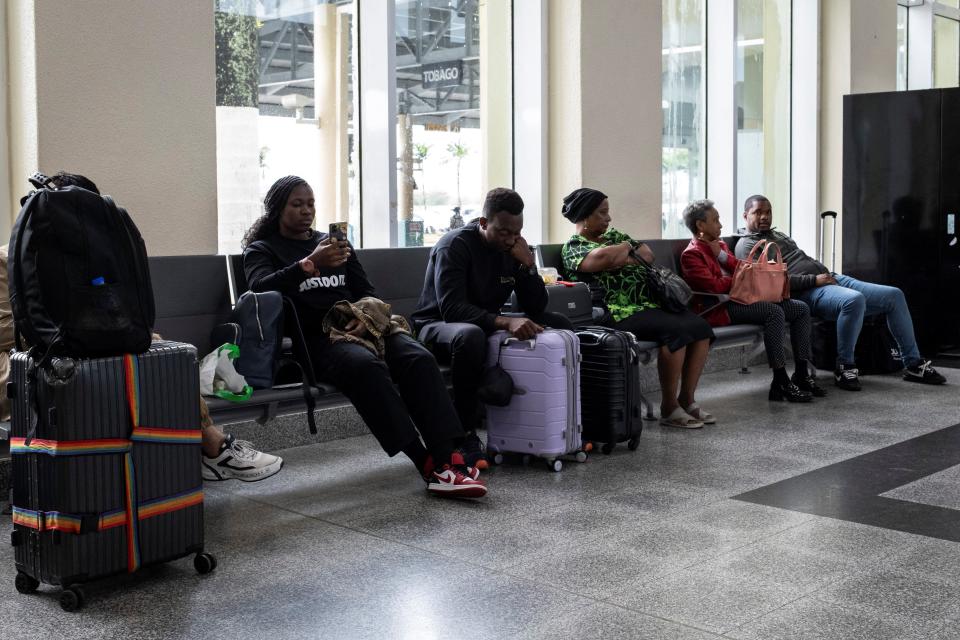 Travelers wait at the Piarco International Airport as flights are delayed and canceled because of Hurricane Beryl (REUTERS)