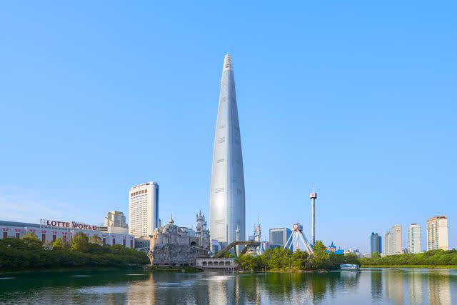 <p>Youngkyu Park</p> The 123-story Lotte World Tower, home of the Signiel Seoul hotel, rises over Lotte World Magic Island, an amusement park.