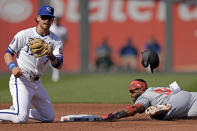 Minnesota Twins' Willi Castro, right, is caught stealing second by Kansas City Royals shortstop Bobby Witt Jr. during the third inning of a baseball game Saturday, March 30, 2024, in Kansas City, Mo. (AP Photo/Charlie Riedel)