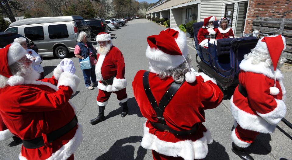 Santas take phone camera photos of each other before the parade at the Irish Village which played host to the annual Northeast Santa Cape Cod Celebration in 2013.