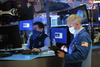 In this photo provided by the New York Stock Exchange, trader Timothy Nick, right, works on the floor, Thursday Dec. 3, 2020. U.S. stocks are inching further into record heights Thursday, as Wall Street continues to coast following its rocket ride last month powered by hopes for coming COVID-19 vaccines. (Nicole Pereira/New York Stock Exchange via AP)