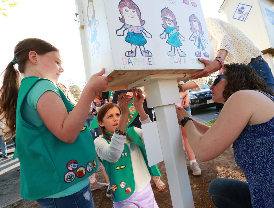 From left, Mackenzie MacEachern, Aubrie Shaw and troop leader Elisa Freeman of Raynham Junior Girl Scout Troop 82256 complete work on the Little Free Pantry at Johnson's Pond in Raynham on Thursday, May 12, 2022. The Little Free Pantry is located right next to the local Cub Scout's Little Free Library.  