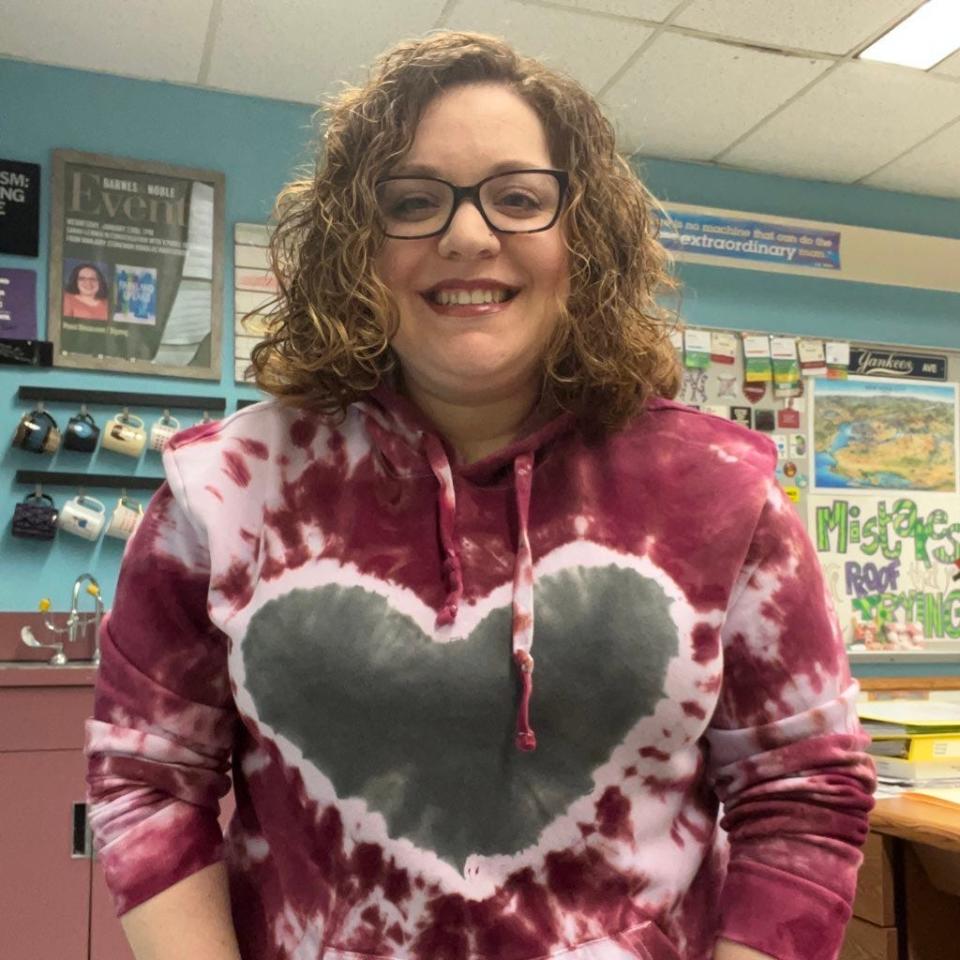 Sarah Lerner in a classroom wearing a hoodie with a heart.