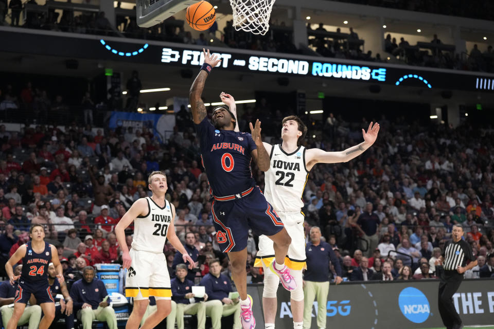 Auburn guard K.D. Johnson (0) shoots in front of Iowa forwards Patrick McCaffery (22) and Payton Sandfort (20) during the second half of a first-round college basketball game in the men's NCAA Tournament in Birmingham, Ala., Thursday, March 16, 2023. Auburn won 83-75. (AP Photo/Rogelio V. Solis)