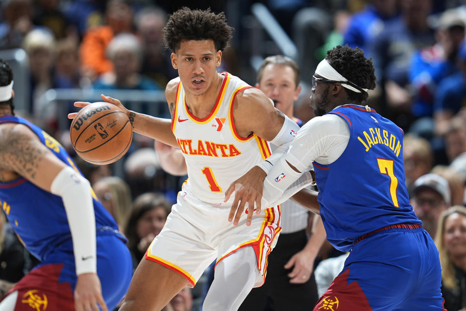 Atlanta Hawks forward Jalen Johnson (1) drives past Denver Nuggets guard Reggie Jackson (7) in the second half of an NBA basketball game Saturday, April 6, 2024, in Denver. (AP Photo/David Zalubowski)