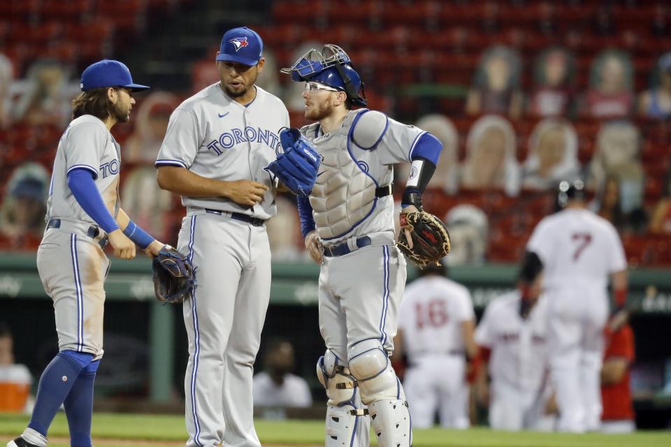 Toronto Blue Jays' Bo Bichette, left, and Danny Jansen, right, talk with Wilmer Font on the mound during the fourth inning of a baseball game against the Boston Red Sox, Saturday, Aug. 8, 2020, in Boston. (AP Photo/Michael Dwyer)