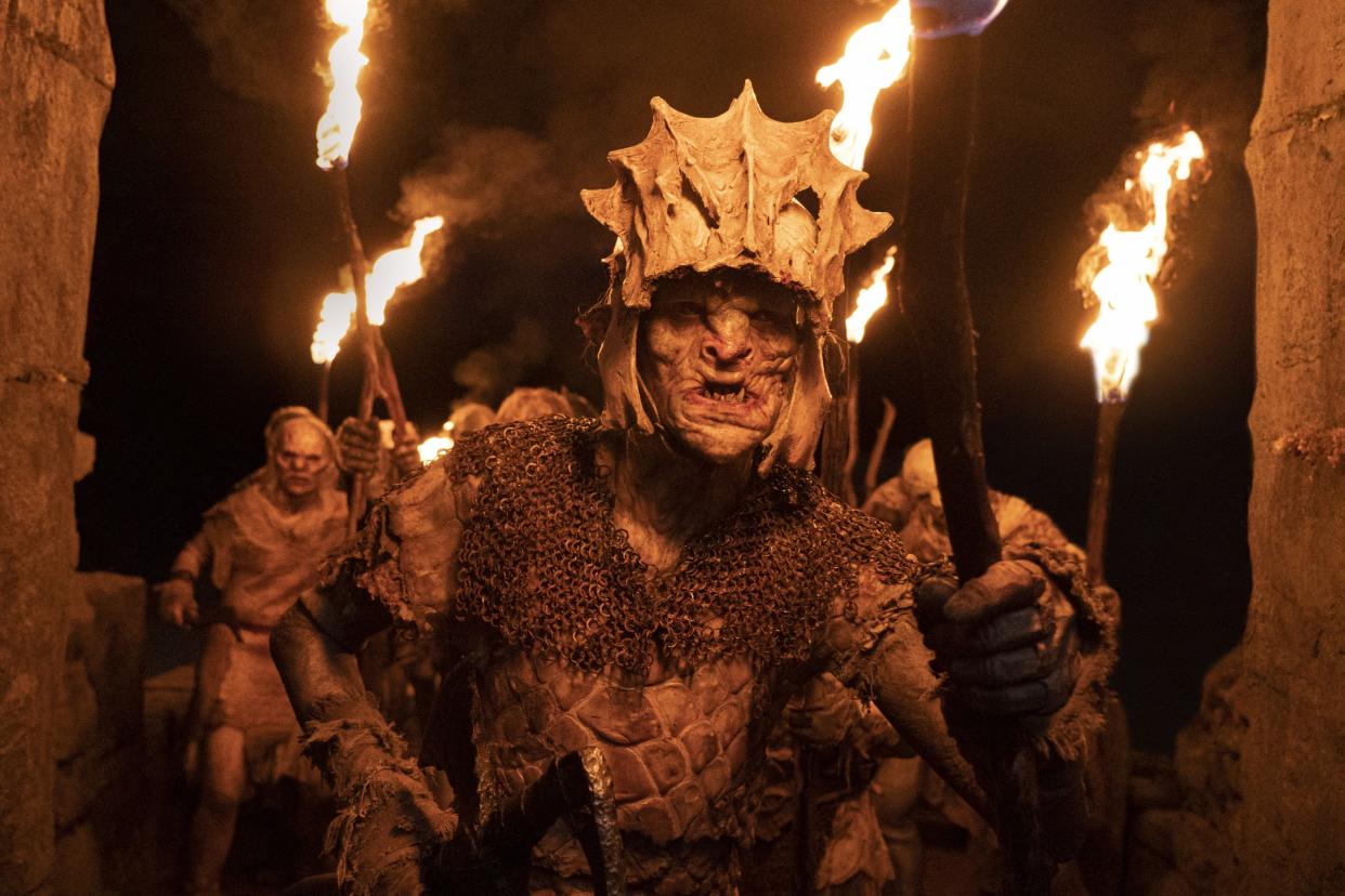 Orcs holding lit torches in a scene from Season 1 of 