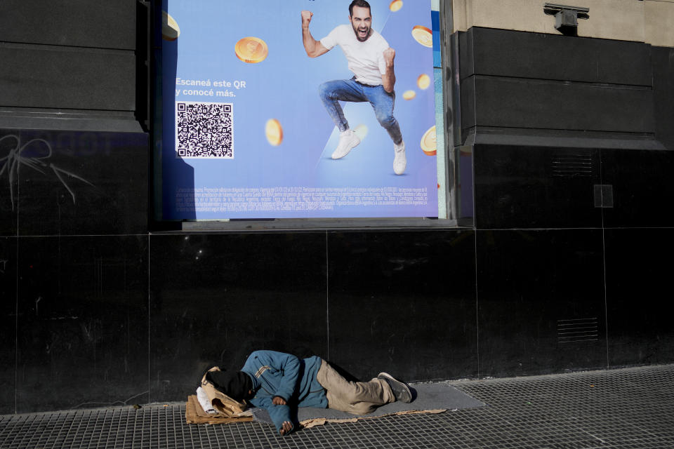 Un vagabundo duerme en una calle de la avenida Corrientes en Buenos Aires, Argentina, el jueves 14 de julio de 2022. (AP Foto/Natacha Pisarenko)