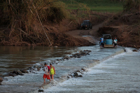 Local residents cross a river using a cable after Hurricane Maria destroyed the town's bridge in San Lorenzo, Morovis, Puerto Rico, October 4, 2017. REUTERS/Alvin Baez