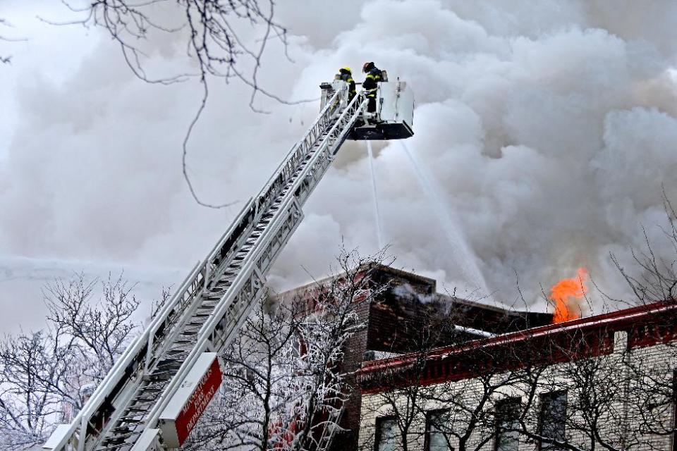 Firefighters work the scene where a fire engulfed several apartment units in the Cedar Riverside neighborhood, in Minneapolis, Wednesday, Jan. 1, 2014. Authorities say at least 13 people have been hurt. (AP Photo/Star Tribune, Elizabeth Flores)