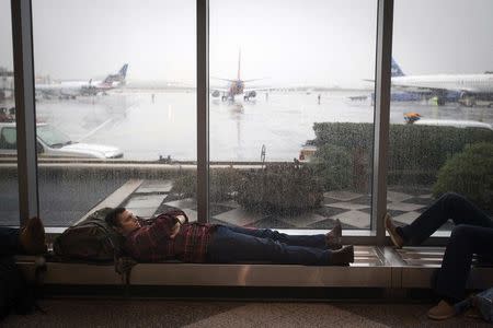 A man sleeps at LaGuardia airport on the day before Thanksgiving, in New York November 26, 2014. REUTERS/Carlo Allegri