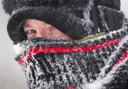 David Reid peers out from his wrappings as he uses a snow blower to clear his driveway during a blizzard near Cremona, Alta., Monday, Dec. 2, 2013. Southern Alberta is under a winter storm warning with temperatures dipping down to -20C with high winds and heavy snowfall. THE CANADIAN PRESS/Jeff McIntosh