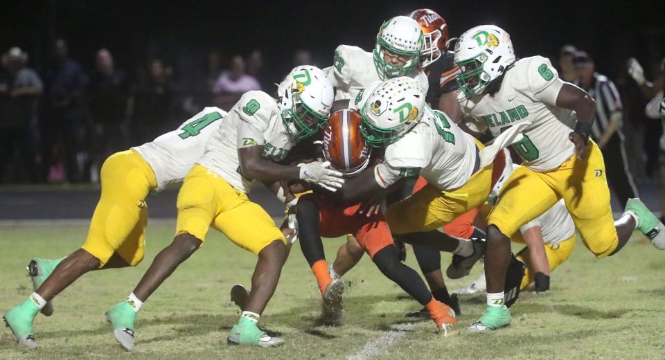 University High's Jermane Hayes #3 slips out of the reach of DeLand High's Michael Hamilton #16, Friday October 20, 2023.