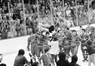 FILE - Montreal Canadiens' captain Serge Savard raises the Stanley Cup over his head as the Canadiens begin to march around the Boston Garden after winning the final game of the Stanley Cup series Saturday night, May 16, 1977 in Boston, Mass. The Canadiens won the game in sudden death overtime 2-1, to win the series in a four-game sweep. With the Boston Bruins now chasing the points and wins marks, members of the record-setting Canadiens, Red Wings and Lightning understand what it's like to be this dominant all season.(AP Photo/File)