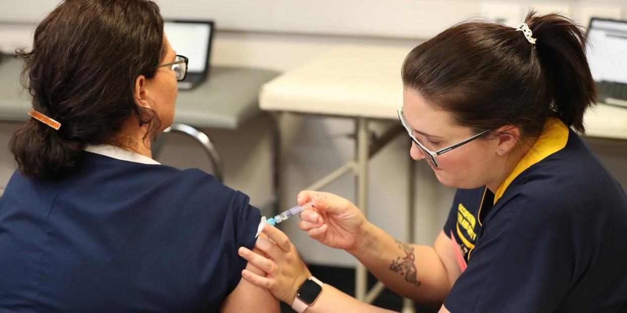 A registered nurse receives a flu vaccination.