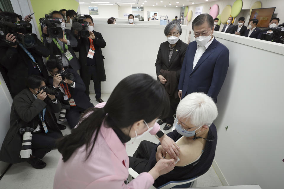 South Korean President Moon Jae-in, top right, watches a doctor receives a shot of AstraZeneca vaccine at a public health center in Seoul, South Korea, Friday, Feb. 26, 2021. South Korea on Friday administered its first available shots of coronavirus vaccines to people at long-term care facilities, launching a mass immunization campaign that health authorities hope will restore some level of normalcy by the end of the year. (Choe Jae-koo/Yonhap via AP)