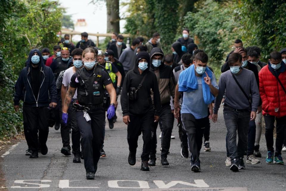 A group of people are escorted by police and Border Force officers away from the beach at St Margaret’s Bay (Gareth Fuller/PA) (PA Wire)