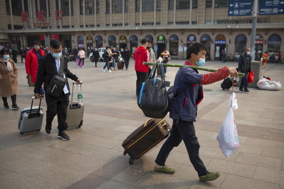 Viajeros cargan con sus equipajes en la estación de tren de Pekín. (Foto: Mark Schiefelbein / Reuters).