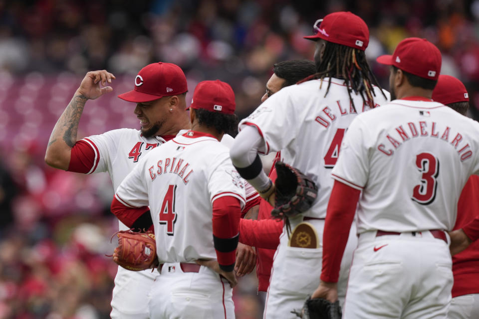 Cincinnati Reds starting pitcher Frankie Montas, left, reacts as his arm is checked after being hit by a line drive by Los Angeles Angels' Taylor Ward in the first inning of a baseball game Sunday, April 21, 2024, in Cincinnati. Montas left the game after the injury. (AP Photo/Carolyn Kaster)