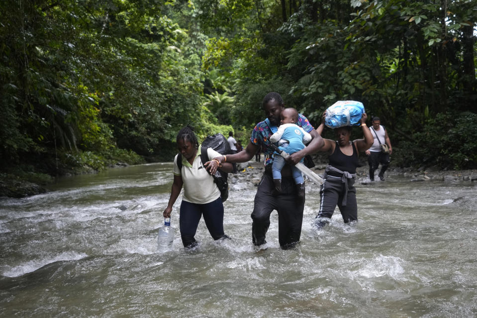 FILE - Haitian migrants wade through a river as they cross the Darien Gap, from Colombia into Panama, hoping to reach the U.S., Oct. 15, 2022. (AP Photo/Fernando Vergara, File)