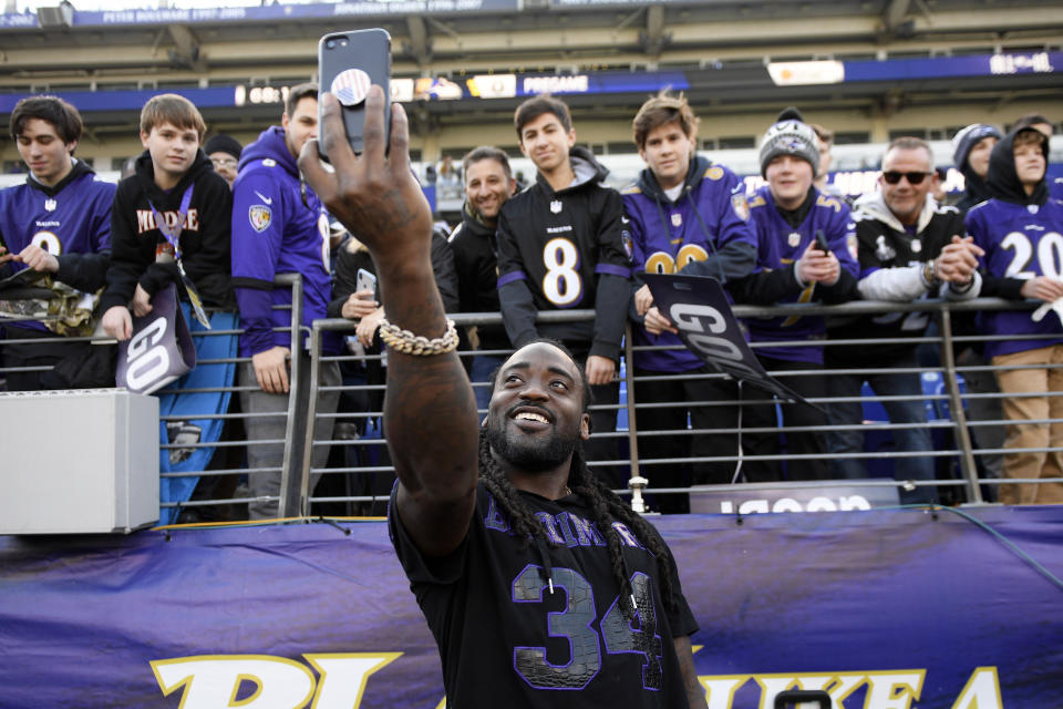 FILE - Baltimore Ravens running back Alex Collins (34) takes a photo with fans before an NFL wild-card playoff football game against the Los Angeles Chargers, Jan. 6, 2019, in Baltimore. Former NFL running back Collins, who played five seasons for the Seattle Seahawks and the Ravens after a terrific college career at Arkansas, has died. He was 28. The Seahawks released a statement from Collins' family that said he died Monday, Aug. 14, 2023. (AP Photo/Nick Wass, File)
