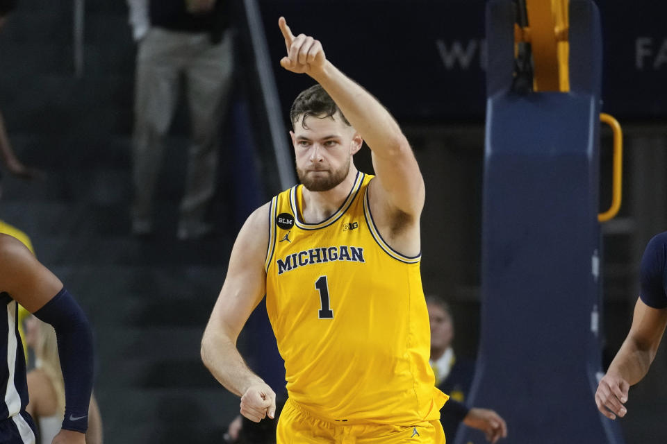 Michigan center Hunter Dickinson (1) reacts to a basket against Virginia in the first half of an NCAA college basketball game in Ann Arbor, Mich., Tuesday, Nov. 29, 2022. (AP Photo/Paul Sancya)