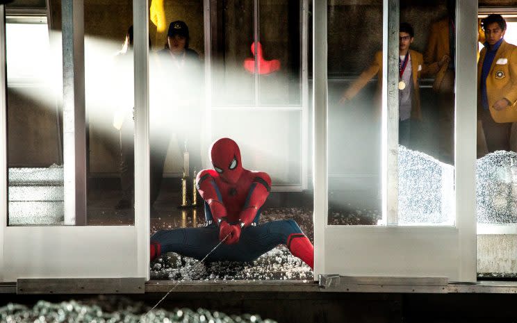 Spider-Man (Tom Holland) works to stop the elevator from falling in 