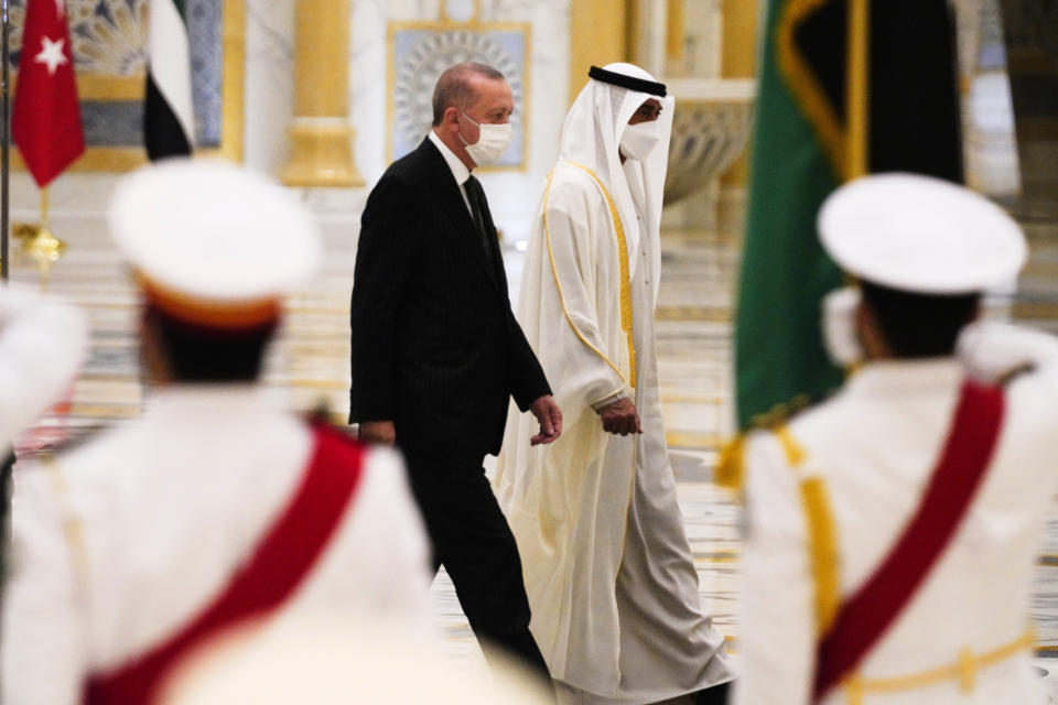 Turkish President Recep Tayyip Erdogan, left, and Abu Dhabi Crown Prince Sheikh Mohammed bin Zayed Al Nahyan look over an honor guard at Qasr Al-Watan in Abu Dhabi, United Arab Emirates, Monday, Feb. 14, 2022. Erdogan traveled Monday to the United Arab Emirates, a trip signaling a further thaw in relations strained over the two nations' approaches to Islamists in the wake of the 2011 Arab Spring. (AP Photo/Jon Gambrell)