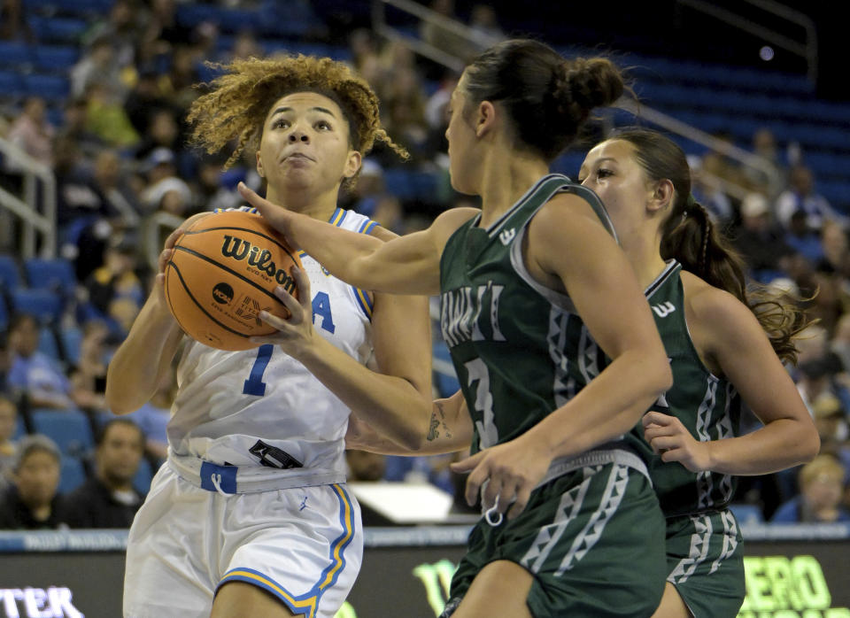 UCLA guard Kiki Rice, left, drives past Hawaii guard Lily Wahinekapu, front right, for a basket in the first half of an NCAA college basketball game Thursday, Dec. 21, 2023, in Los Angeles. (AP Photo/Jayne Kamin-Oncea)