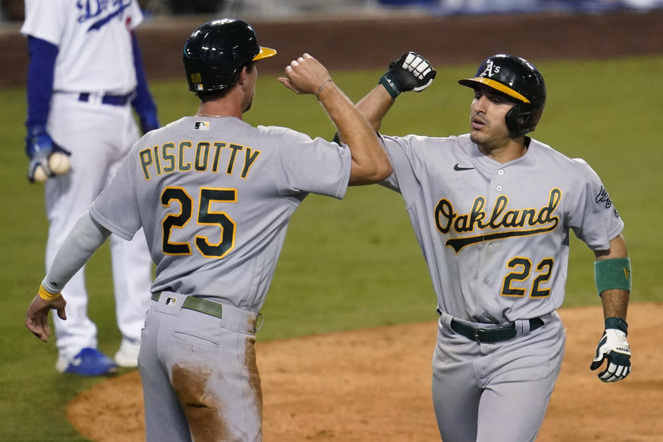 Oakland Athletics' Ramon Laureano, right, celebrates his two-run home run with Stephen Piscotty (25) during the ninth inning of the team's baseball game against the Los Angeles Dodgers on Wednesday, Sept. 23, 2020, in Los Angeles. (AP Photo/Marcio Jose Sanchez)