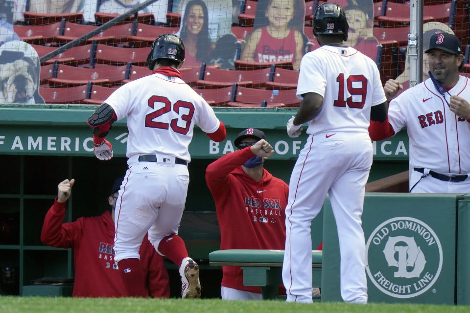 Boston Red Sox's Michael Chavis (23) and Jackie Bradley Jr. (19) are welcomed to the dugout after Chavis hit a two-run home run off a pitch by New York Yankees' Deivi Garcia in the second inning of a baseball game Sunday, Sept. 20, 2020, in Boston. (AP Photo/Steven Senne)
