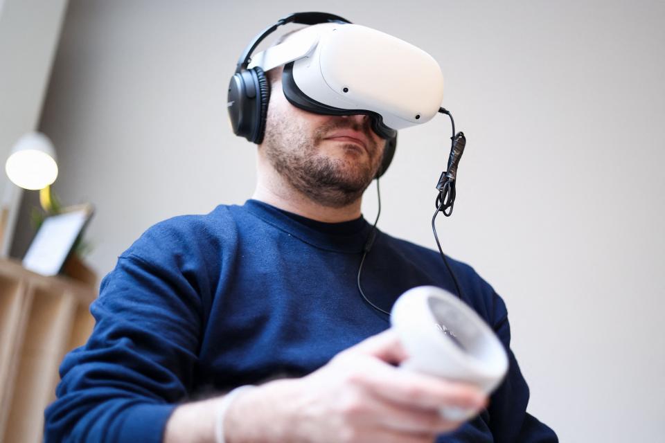 A Meta worker uses a Meta Quest VR headset at the Meta showroom in Brussels on December 07, 2022.