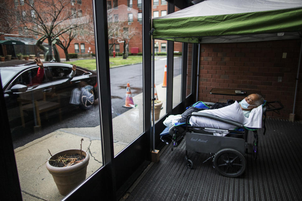 Family members wave goodbye to nursing home resident Barbara Farrior, 85, at the end of their visit at the Hebrew Home at Riverdale in New York. (AP Photo/Eduardo Munoz Alvarez)