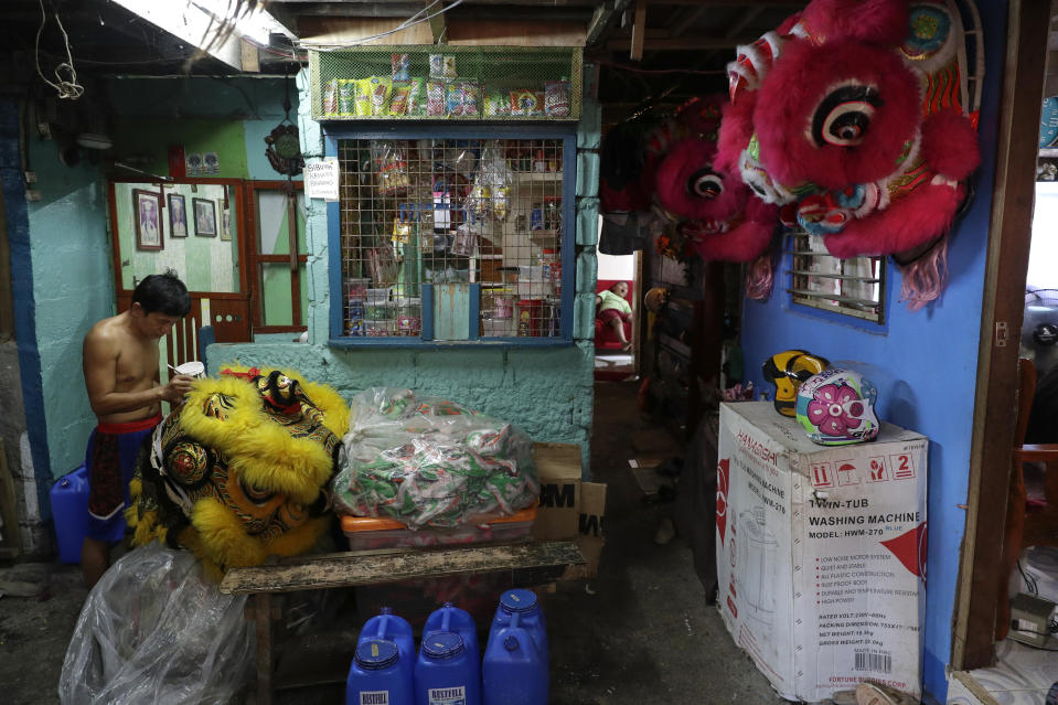 Robert Sicat paints a lion head as members of a Dragon and Lion dance group seek other ways to earn a living at a creekside slum in Manila's Chinatown, Binondo, Philippines on Feb. 4, 2021. The Dragon and Lion dancers won't be performing this year after the Manila city government banned the dragon dance, street parties, stage shows or any other similar activities during celebrations for Chinese New Year due to COVID-19 restrictions leaving several businesses without income as the country grapples to start vaccination this month. (AP Photo/Aaron Favila)