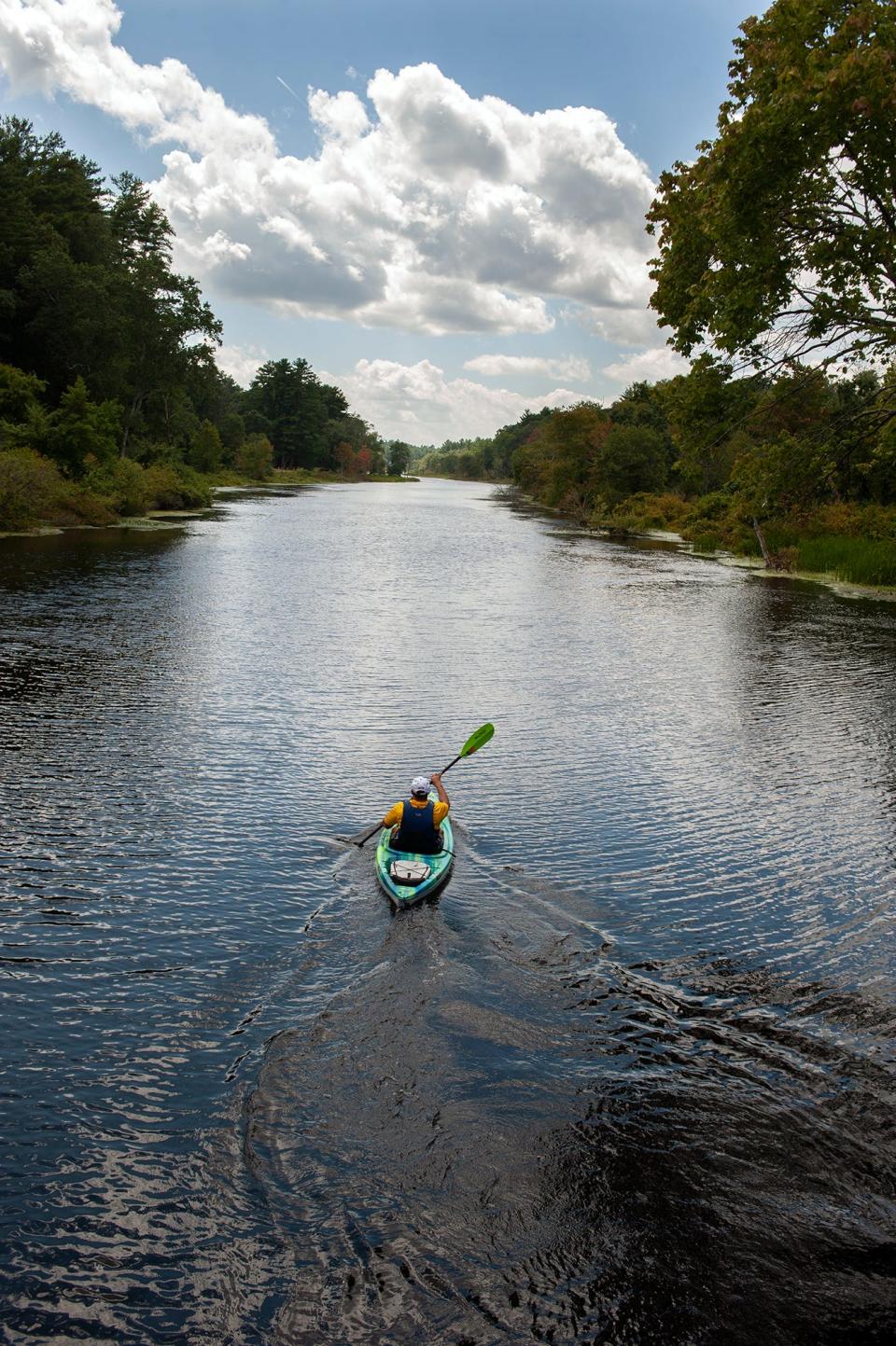 A kayaker paddles on the Charles River near the Farm Road Bridge in Dover, Aug. 11, 2023.