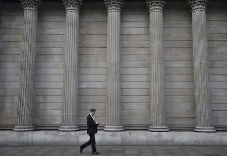 FILE PHOTO - A man walks past the Bank of England in the City of London, Britain, February 14, 2017. REUTERS/Hannah McKay/File Photo