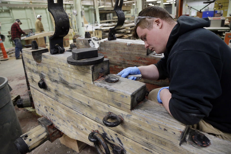 A maintenance facility worker restores wood for the USS Constitution, Wednesday, April 5, 2017, at the Charlestown Navy Yard in Boston. The world's oldest commissioned warship afloat is scheduled to return to the waters in late July. (AP Photo/Elise Amendola)