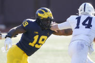 FILE - In this Saturday, Nov. 28, 2020 file photo, Michigan defensive lineman Kwity Paye (19) reaches in on Penn State quarterback Sean Clifford (14) during the second half of an NCAA college football game in Ann Arbor, Mich. With Oregon's Penei Sewell likely to be long gone, two other heralded tackles could be available to the Vikings at No. 14: Northwestern's Rashawn Slater and Virginia Tech's Christian Darrisaw. Slater has a random connection to Minnesota: His father, Reggie Slater, played in the NBA for the Timberwolves in parts of two seasons.(AP Photo/Carlos Osorio, File)