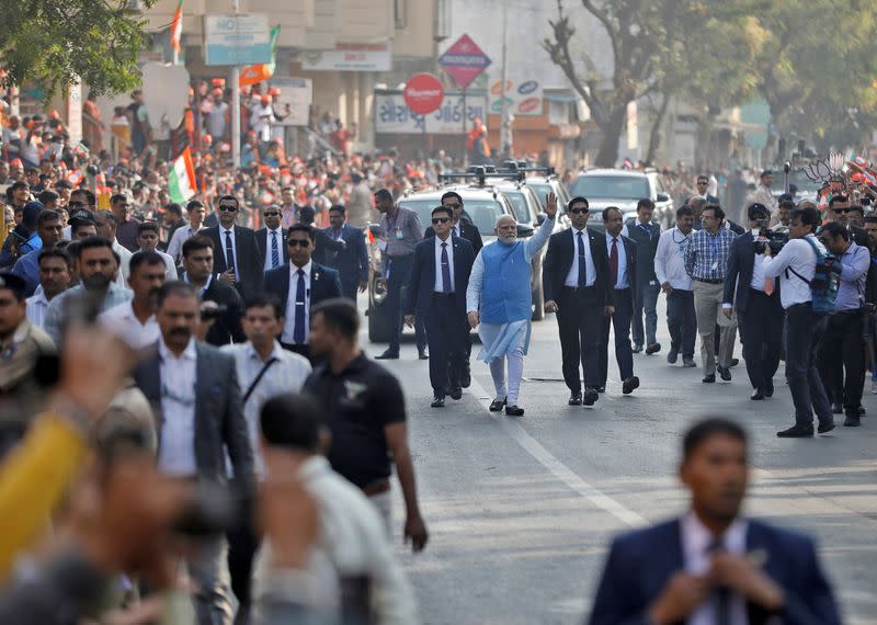 PM Modi waves to his supporters as he arrives to cast his vote, in Ahmedabad