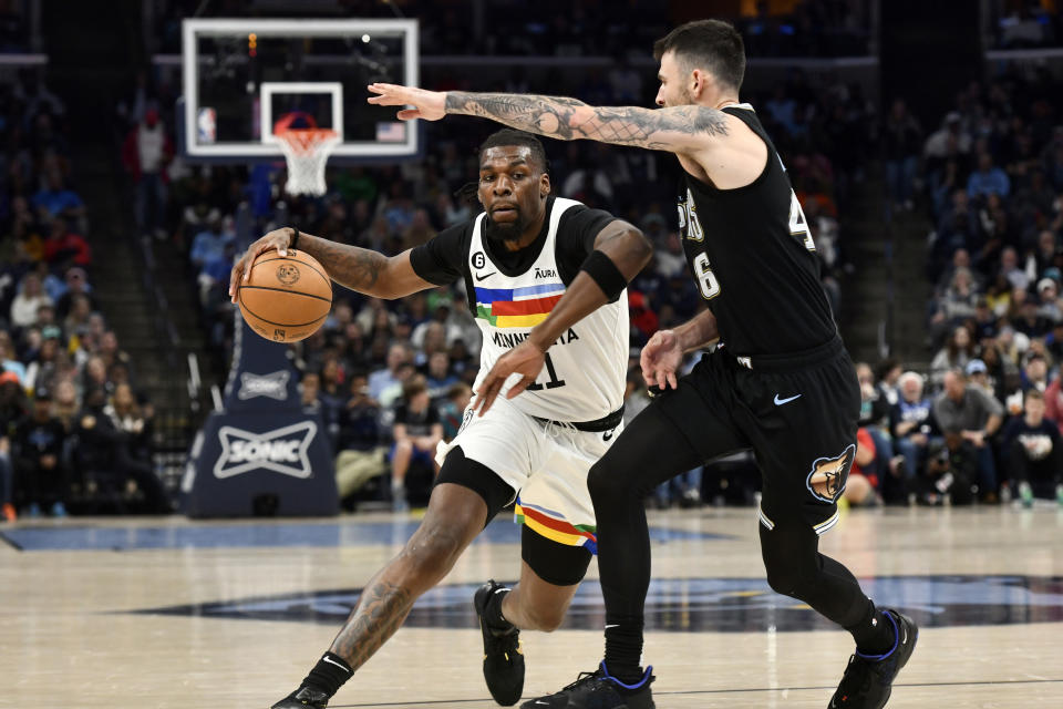 Minnesota Timberwolves forward Naz Reid, left, handles the ball against Memphis Grizzlies guard John Konchar (46) in the second half of an NBA basketball game Friday, Feb. 10, 2023, in Memphis, Tenn. (AP Photo/Brandon Dill)