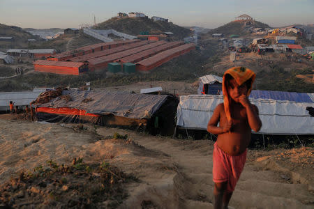 A Rohingya refugee child stands on a hill above the camp for widows and orphans inside the Balukhali camp near Cox's Bazar, Bangladesh, December 5, 2017. More than 230 women and children live at a so-called widows camp built by fellow refugees with the help of donor funds for Rohingya widows and orphans to offer them better protection and shelter. REUTERS/Damir Sagolj