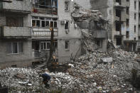 A man cleans debris of the destroyed house after recent Russian air strike in Chasiv Yar, Ukraine, Sunday, Nov. 27, 2022. Shelling by Russian forces struck several areas in eastern and southern Ukraine overnight as utility crews continued a scramble to restore power, water and heating following widespread strikes in recent weeks, officials said Sunday. (AP Photo/Andriy Andriyenko)