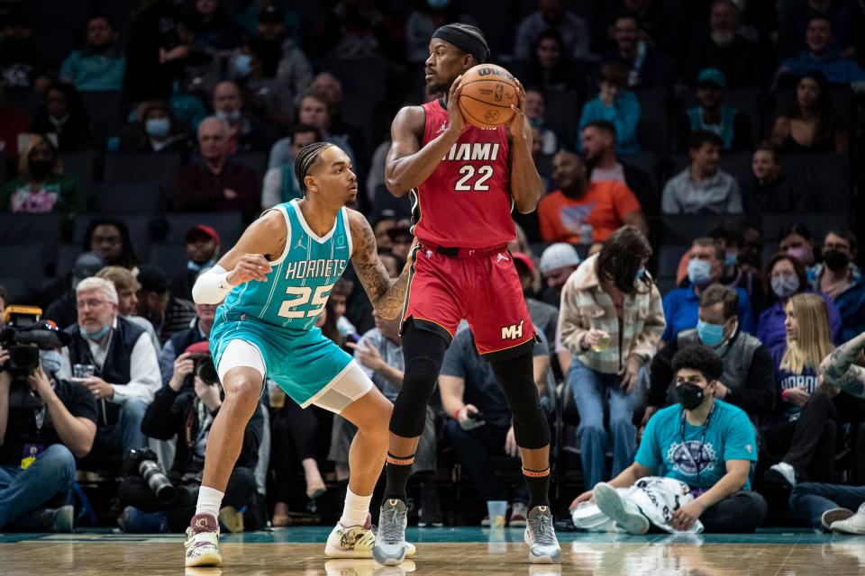 Charlotte Hornets forward P.J. Washington (25) defends against Miami Heat forward Jimmy Butler (22) during the first half of an NBA basketball game Thursday, Feb. 17, 2022, in Charlotte, N.C. (AP Photo/Matt Kelley)